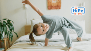 Petite fille atteinte d'un trouble déficitaire de l'attention qui fait une acrobatie sur un lit