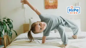 Petite fille atteinte d'un trouble déficitaire de l'attention qui fait une acrobatie sur un lit