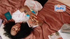 Adolescente allongée sur son lit regardant son téléphone portable.