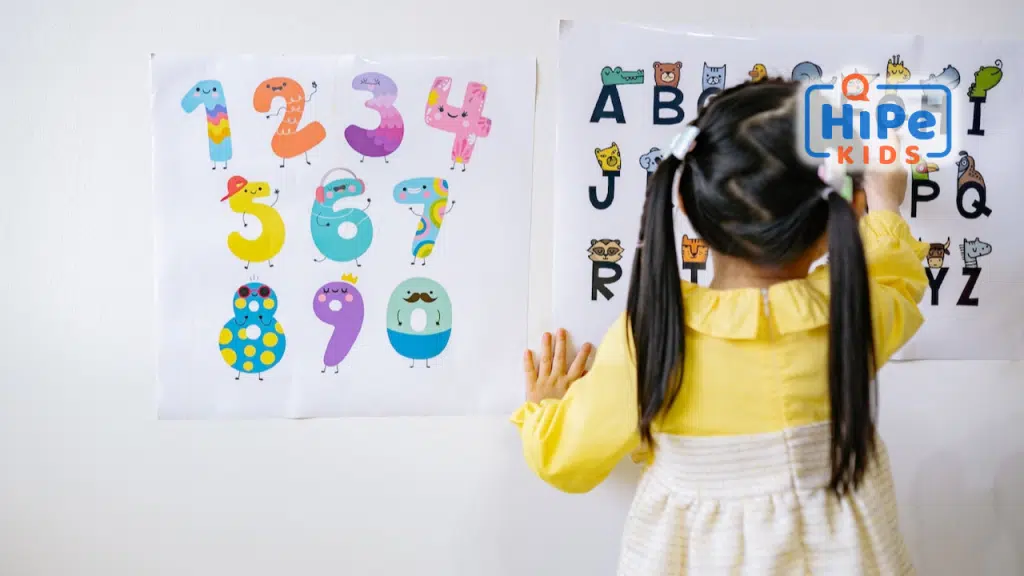 Petite fille de dos qui apprend l'alphabet et à compter.
