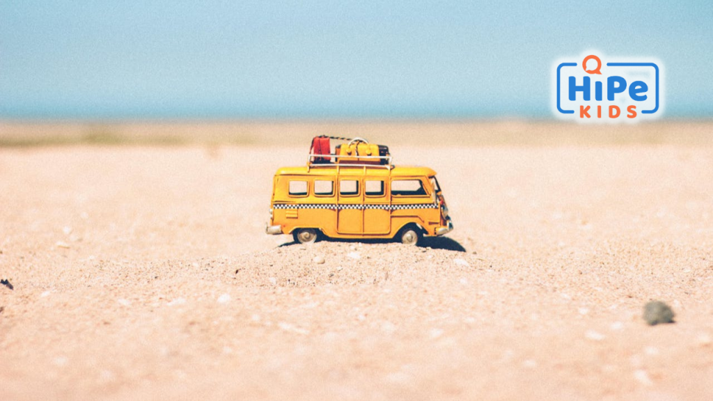Van miniature jaune posé dans le sable.